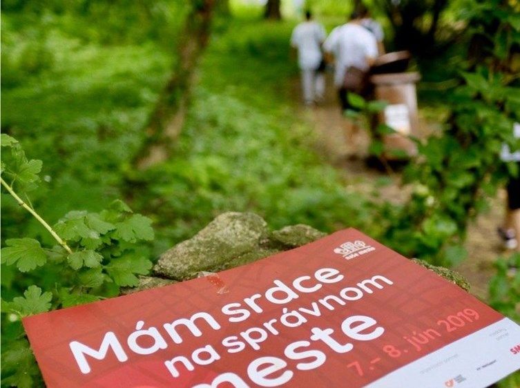 tabuľka položená na zemy, na tabuľke je napísané: "mám srdce na správnom meste", v pozadí sú ľudia