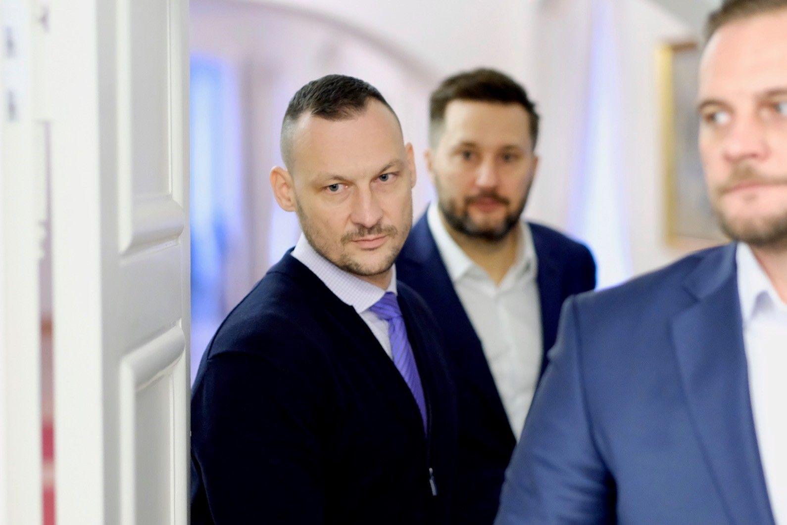 detail na Mareka Gajdoša prechádzajúceho cez prah dverí, za ním ide primátor bratislavy Matúš Vallo